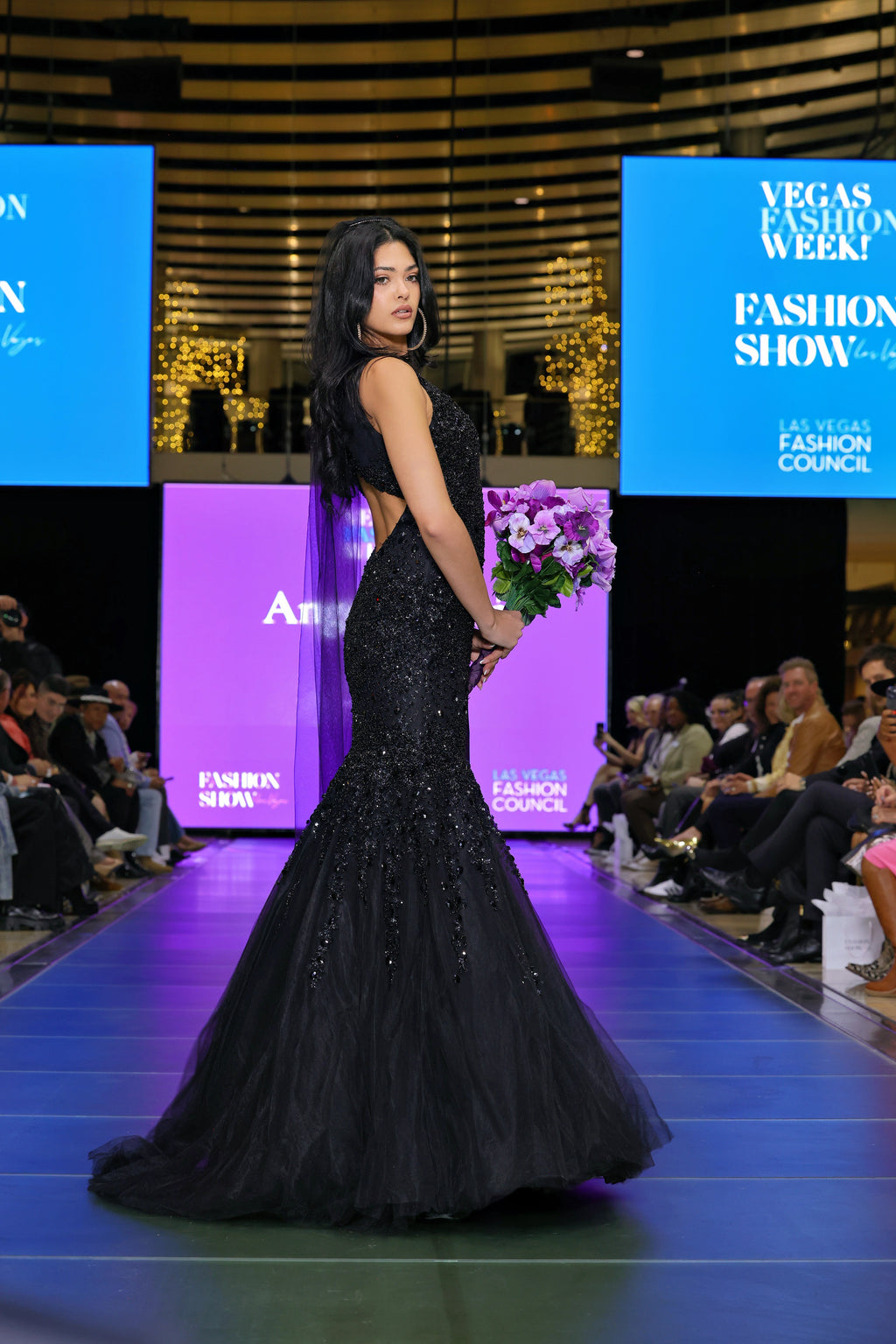 Woman in a black evening gown at a fashion show