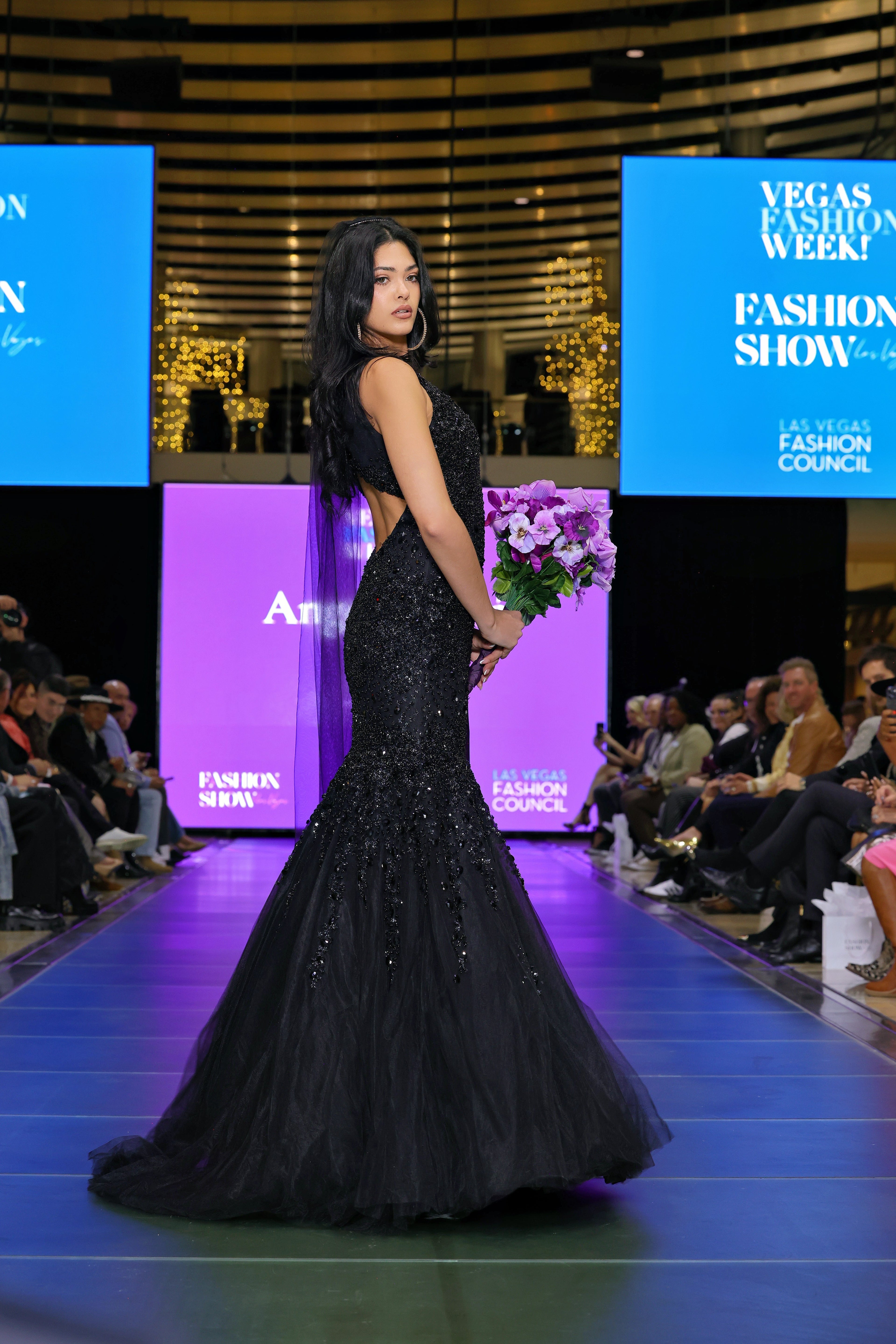 Woman in a black evening gown at a fashion show