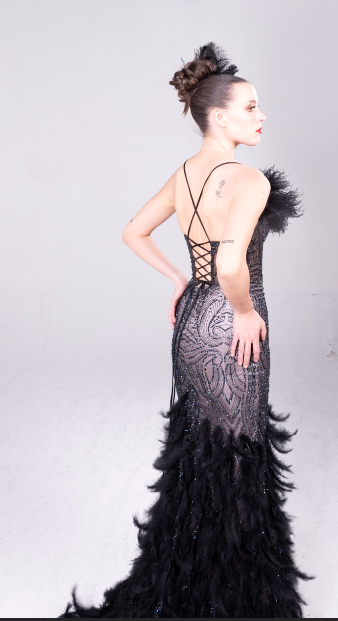 Beaded gown with fleah colored lining, feather details on the bodice and all over the maermaid style train.