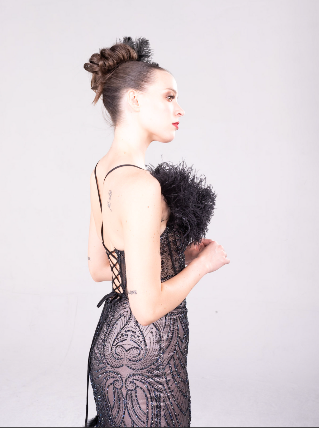 Beaded gown with fleah colored lining, feather details on the bodice and all over the maermaid style train.