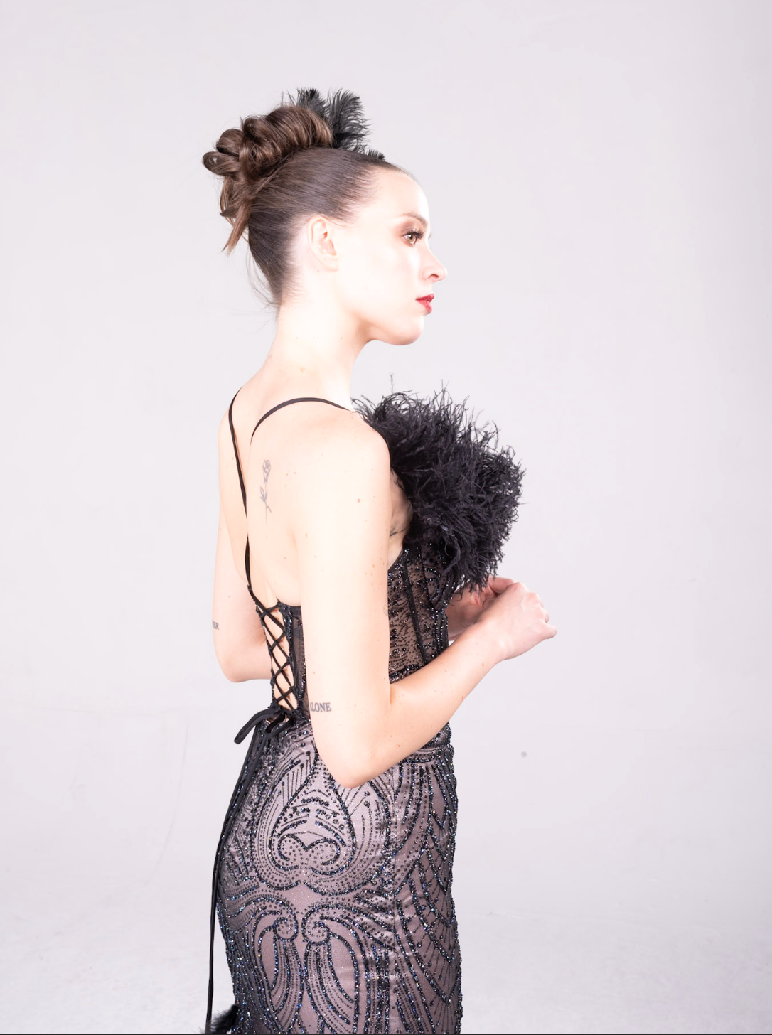 Beaded gown with fleah colored lining, feather details on the bodice and all over the maermaid style train.