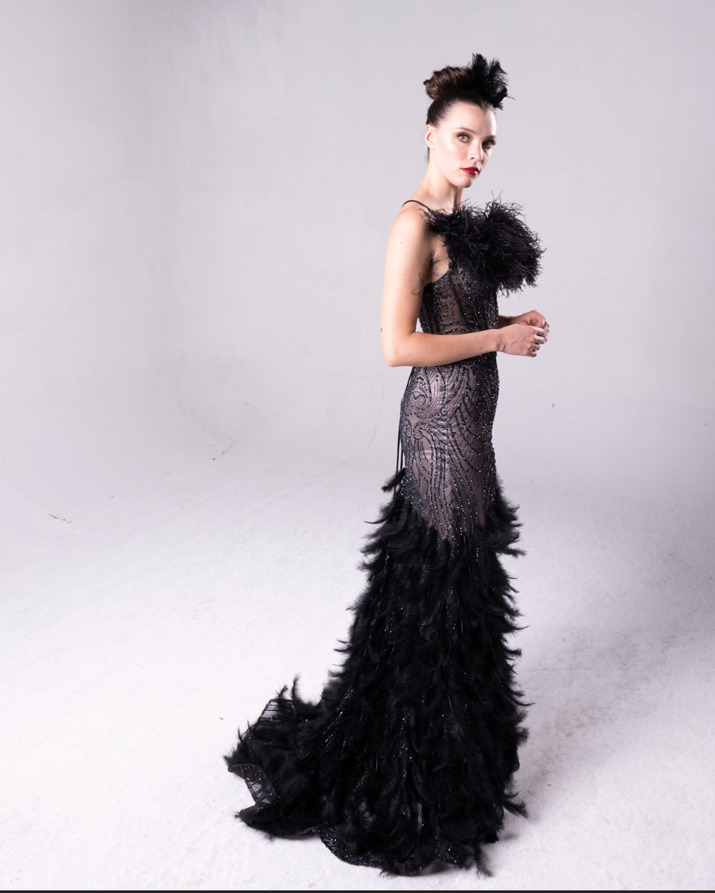 Beaded gown with fleah colored lining, feather details on the bodice and all over the maermaid style train.