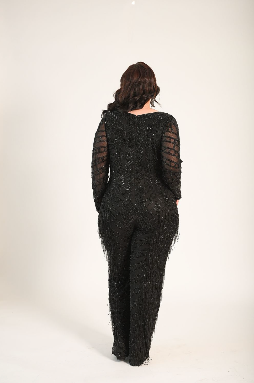 Beaded jumpsuit, with sheer sleeves. Sheer panel along the bust line. V-neckline. Back zipper. 