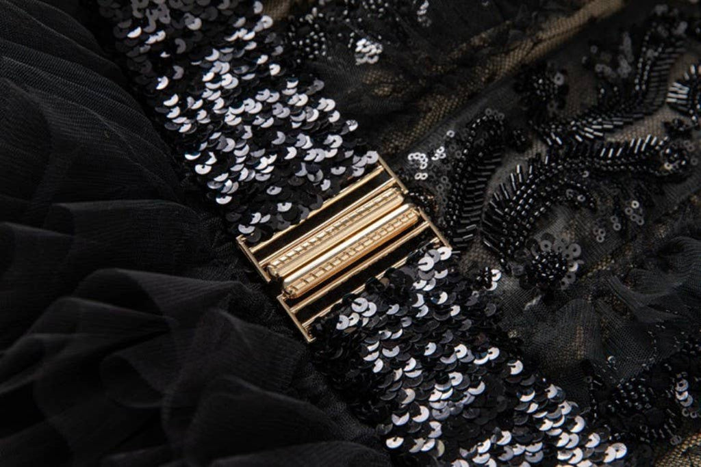 Close-up of the black sequined belt with a gold buckle 