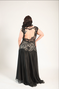Black gown in a lace fabric, sheer cutouts on the waist, with a backless design. High split. 