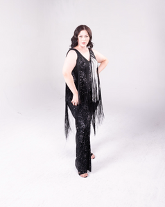 sequin fringe jumpsuit with color block detail. One side is all black, and a portion of it is white. Fringe hangs down from the neckline around the bodice of the jumpsuit