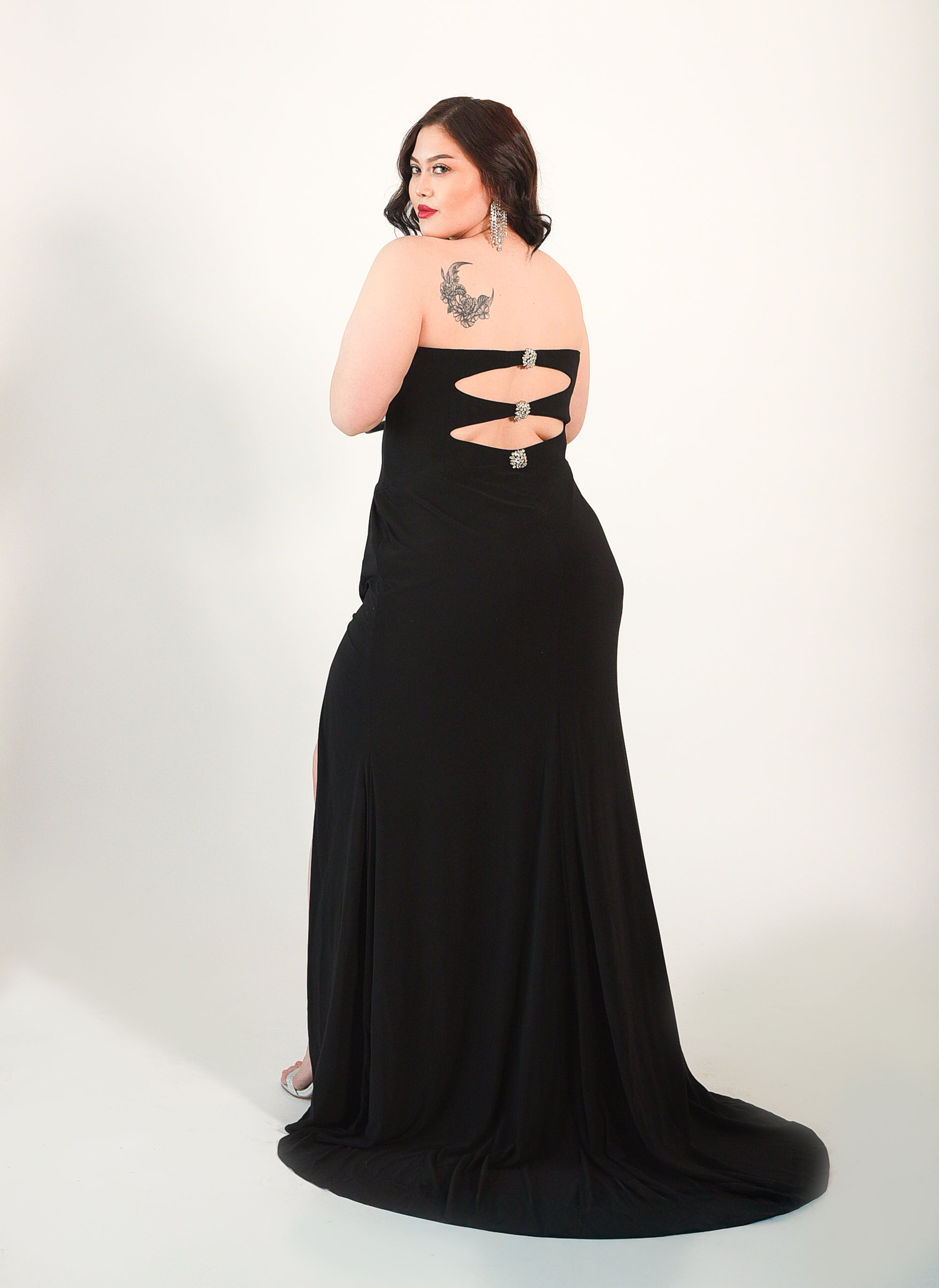 Strapless gown with crystal beaded accents. Cutouts in the front and back. High Split. Side zipper. 