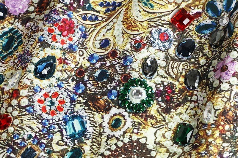 Close-up of a gemstone print fabric with colorful gemstones accenting the garment 