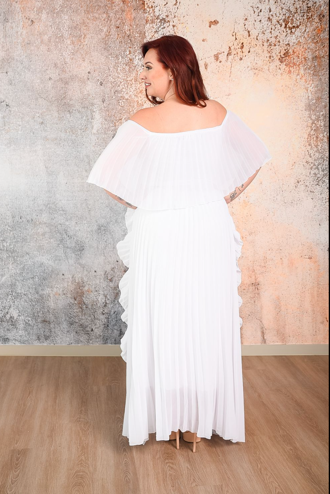 white pleated maxi dress with ruffle detaIls on the side and a 