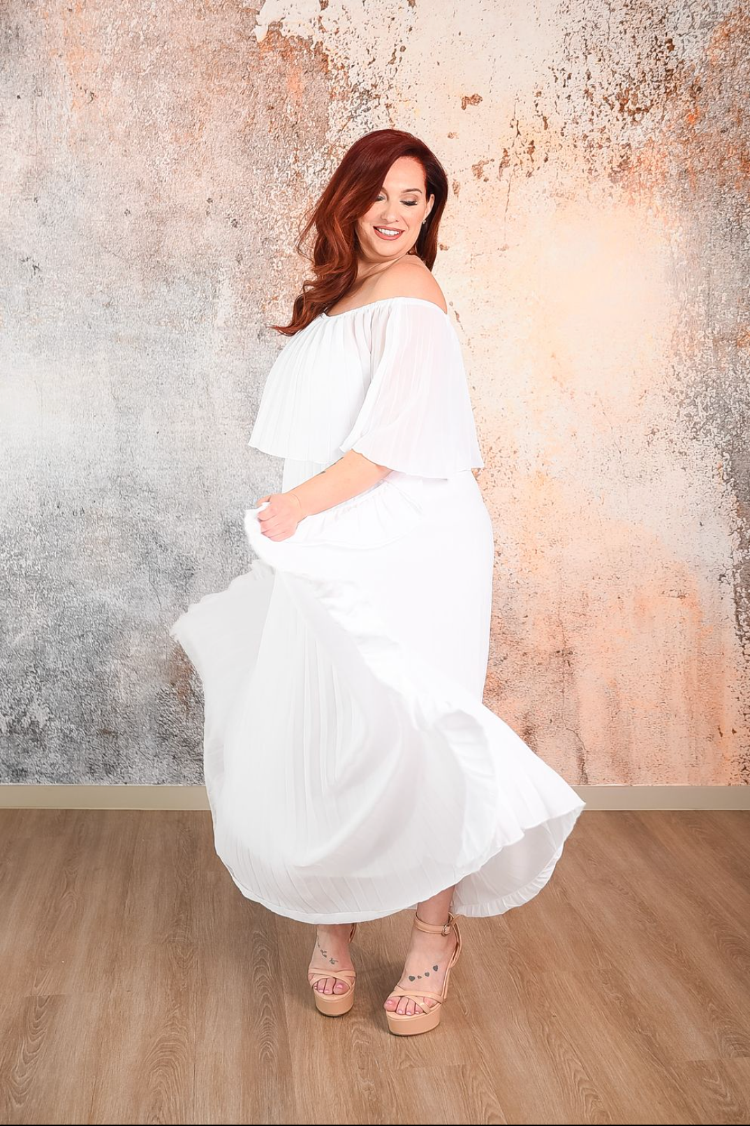 white pleated maxi dress with ruffle detaIls on the side and a 