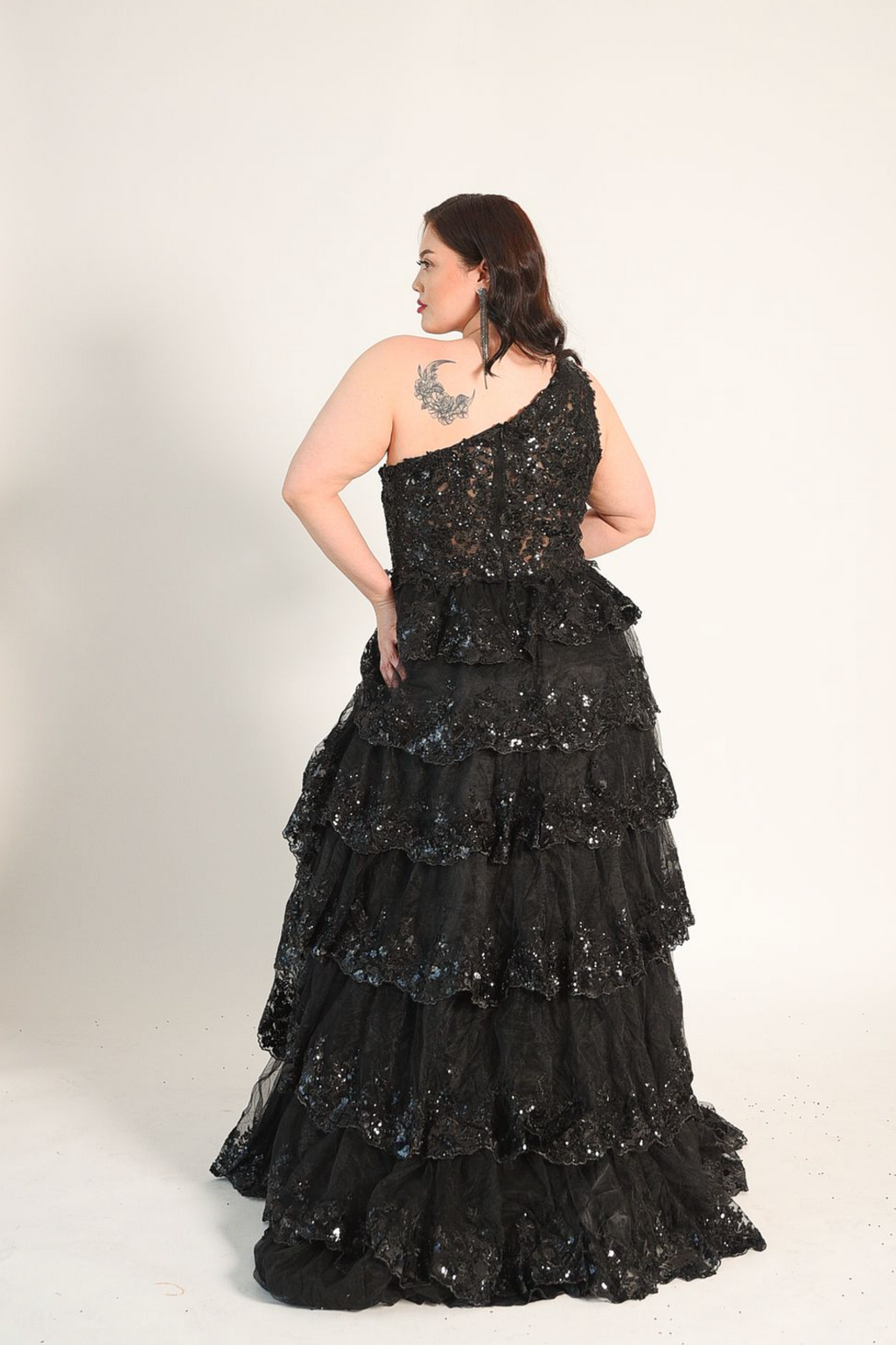 One shoulder gown, with a full skirt. Cacading tiered ruffles. Split on the left side. Back zipper. 