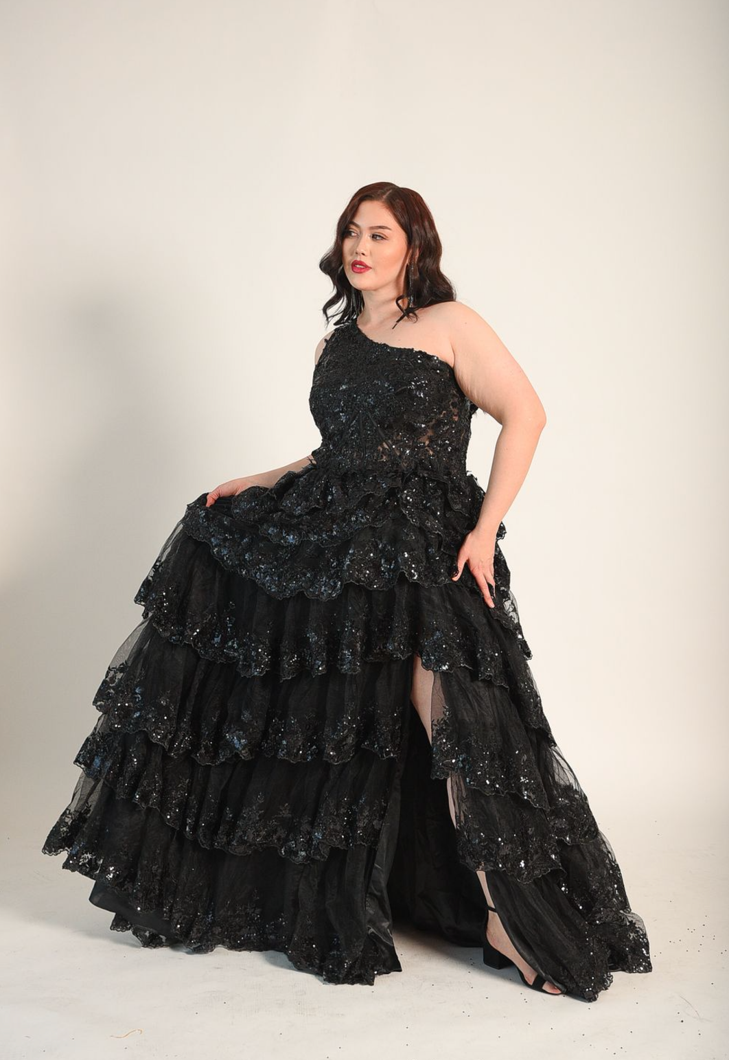 One shoulder gown, with a full skirt. Cacading tiered ruffles. Split on the left side. Back zipper. 