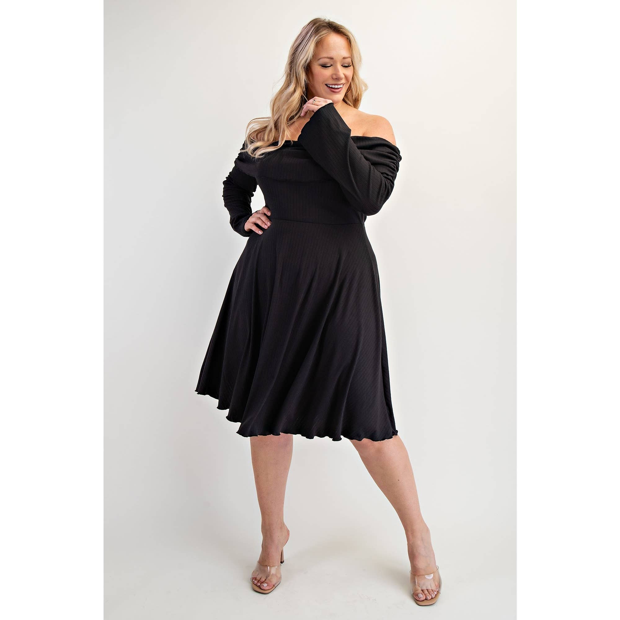 Woman wearing a black off-shoulder dress showcaing the bell sleeve 