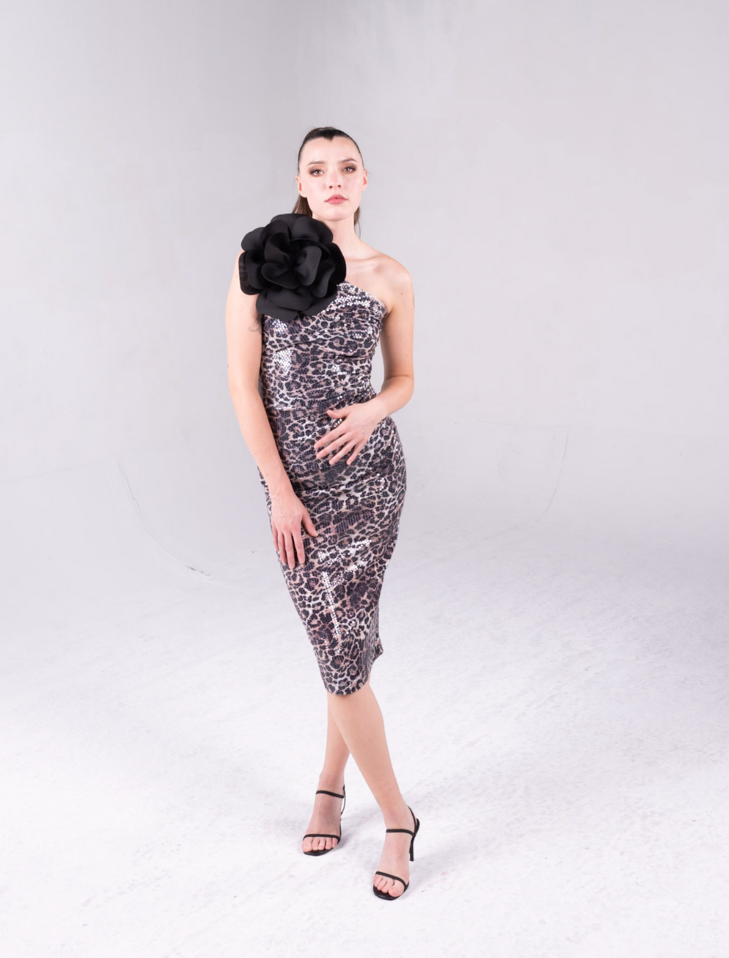 leopard print sequin fabric, the dress is one shoulder with an exaggerated flower at the top of the bodice. 