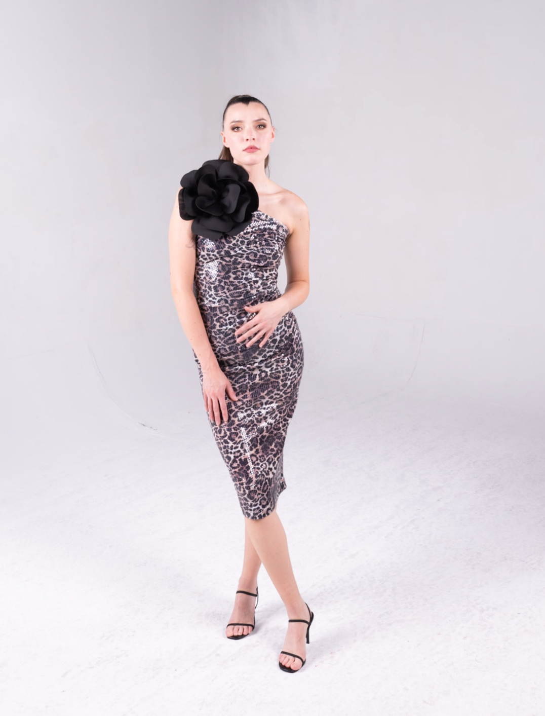 leopard print sequin fabric, the dress is one shoulder with an exaggerated flower at the top of the bodice. 