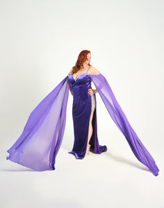 Formal gown with a high split adorned with crystal details. Cape sleeves. In a stretch velvet material. 
