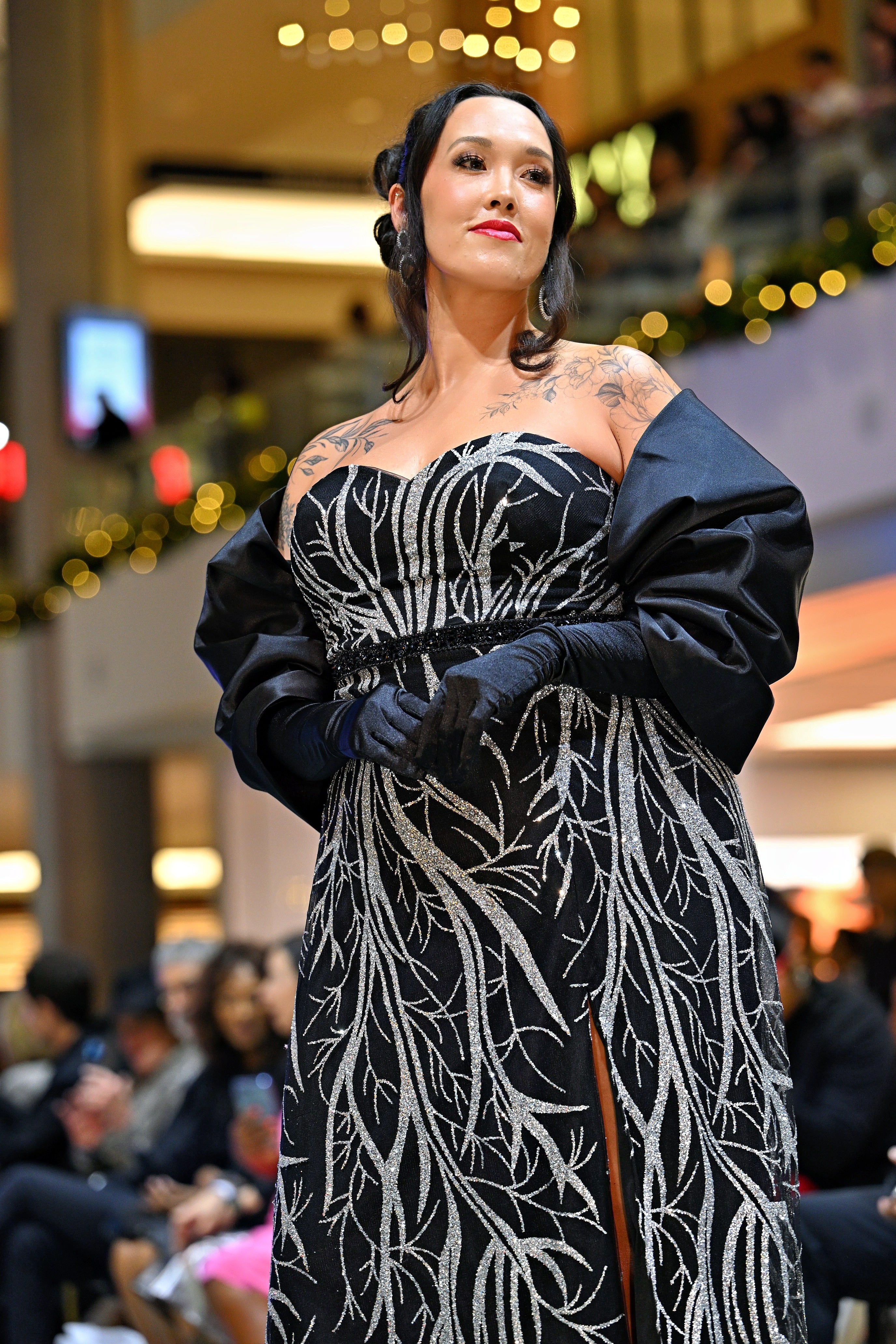 A woman wearing a black and silver patterned dress. 