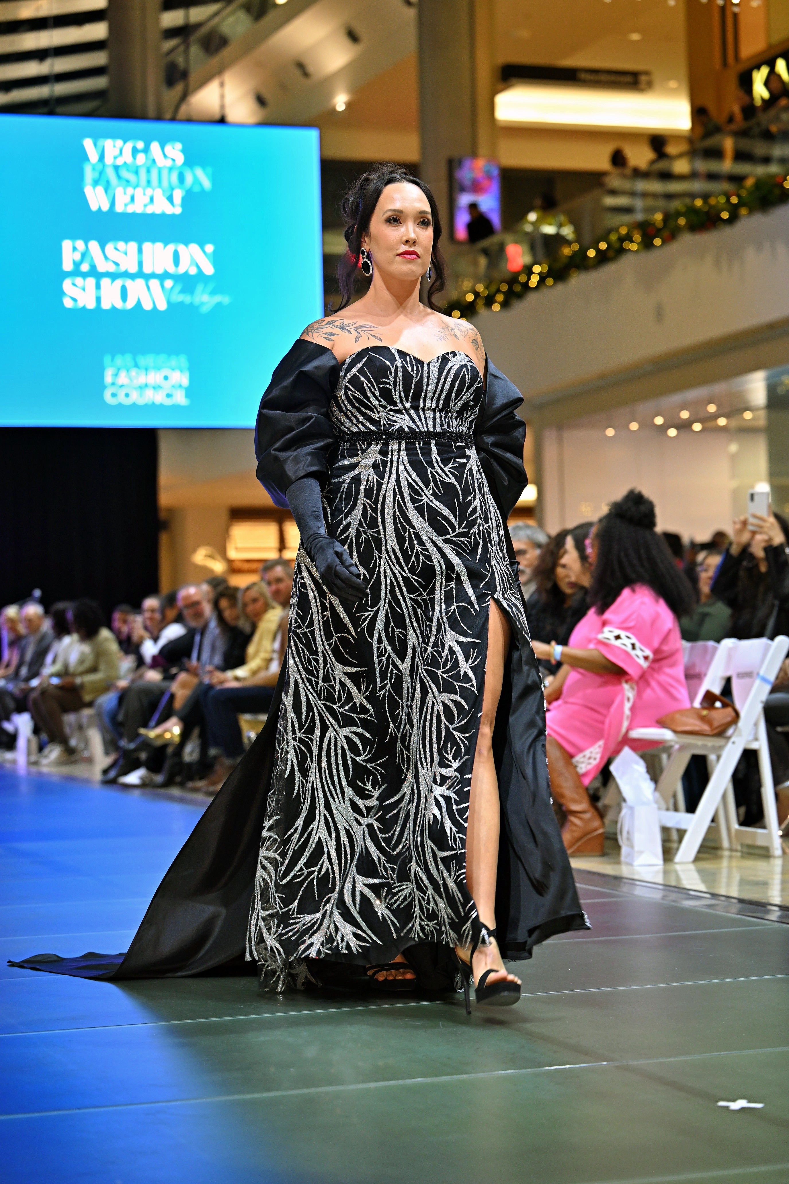 A woman in a black and silver patterned gown