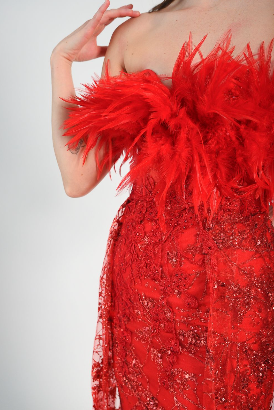 Red sequin gown with an overskirt, feather details across the bust, fitted gown style. Back zipper. 