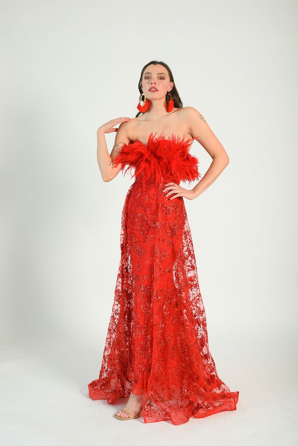 Red sequin gown with an overskirt, feather details across the bust, fitted gown style. Back zipper. 