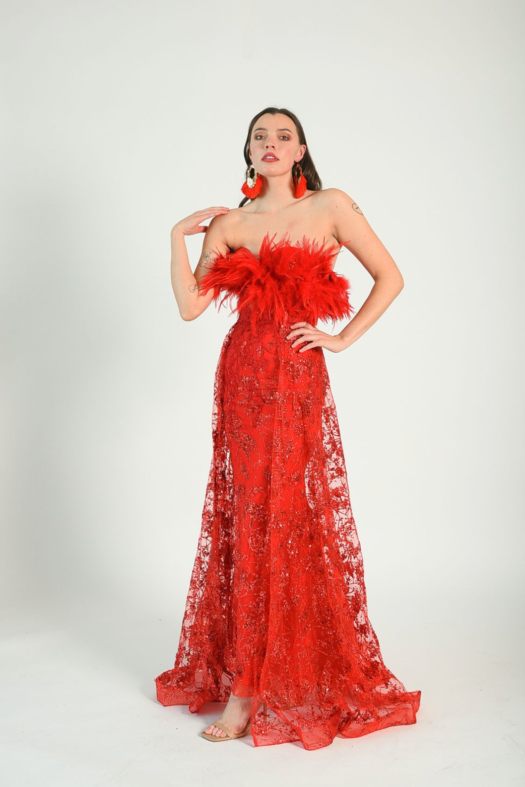 Red sequin gown with an overskirt, feather details across the bust, fitted gown style. Back zipper. 