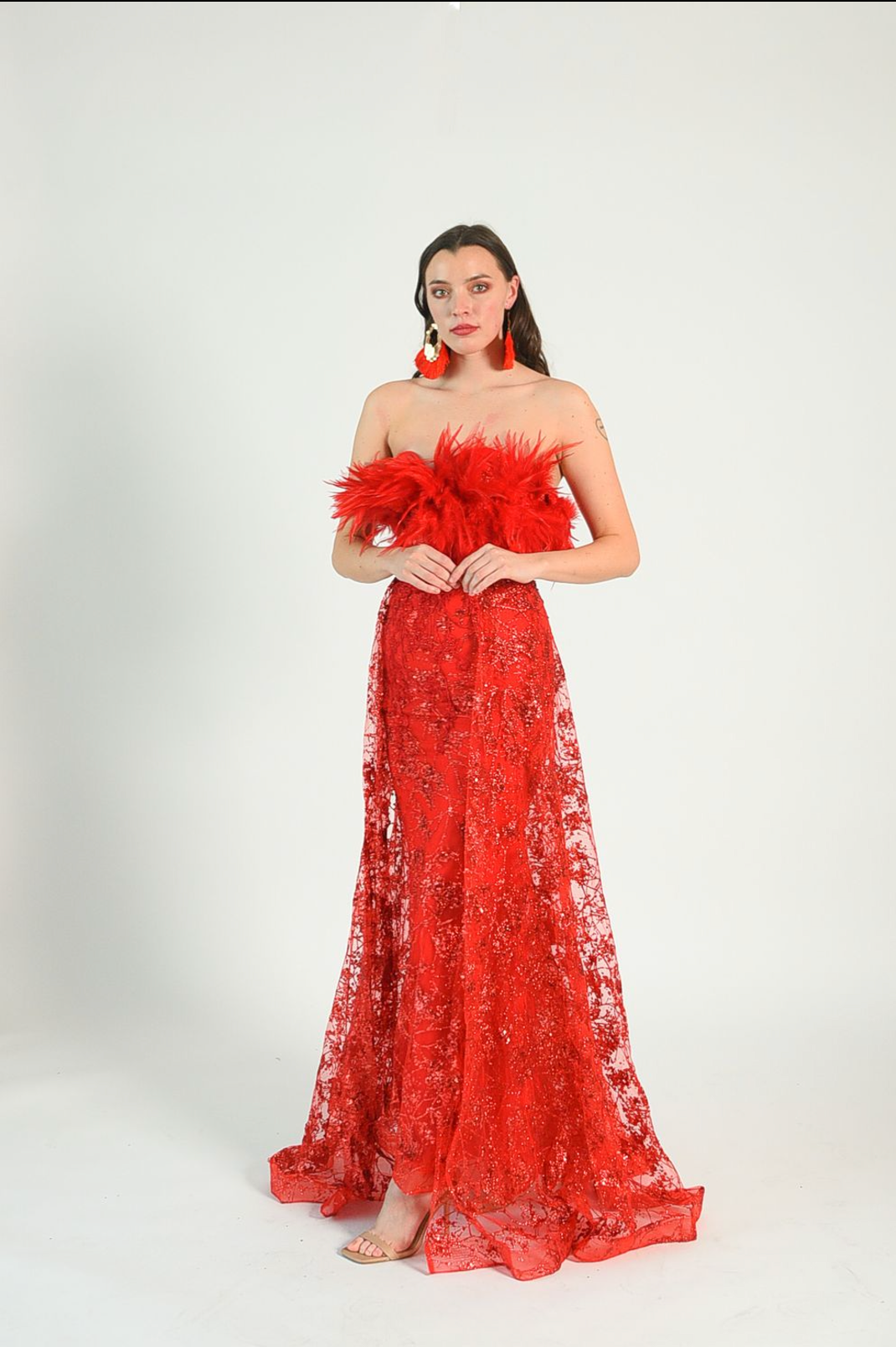 Red sequin gown with an overskirt, feather details across the bust, fitted gown style. Back zipper. 