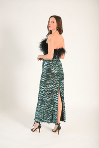 Blue/green sequin fabric with black zig-zag lines across each other. Black feathers adorn the bodice. The dress is strapless. 